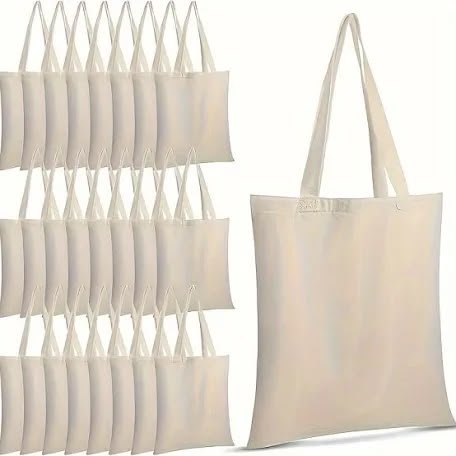 Stacked rows of natural cotton tote bags beside a single made-up bag
