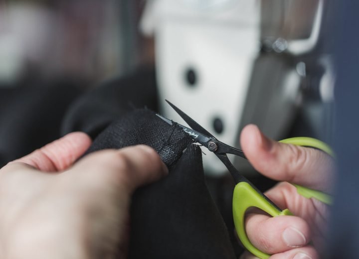 Shears cutting cloth to length on a cutting table